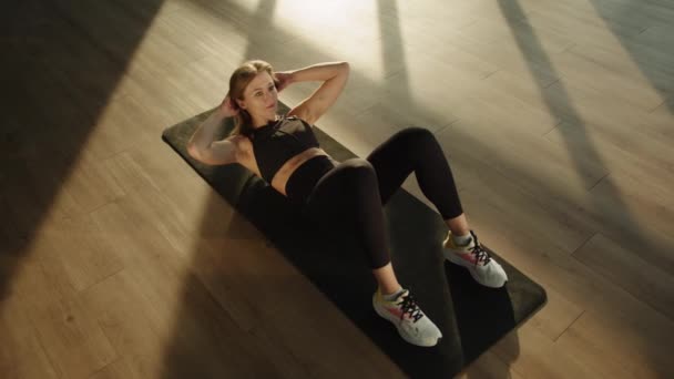 여자는 그녀의 그녀의 손으로 트위스트를하고 방에서 운동하고있다 그녀는 스포츠웨어에 검은색 — 비디오
