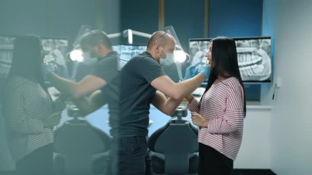 Jovem Profissional Dental Camiseta Cinza Calças Experimentando Folheados Para Mulher — Vídeo de Stock