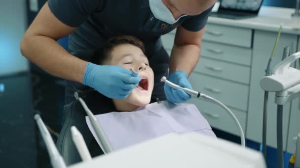 Odontólogo Joven Profesional Que Retira Cavidad Del Diente Del Niño — Vídeos de Stock