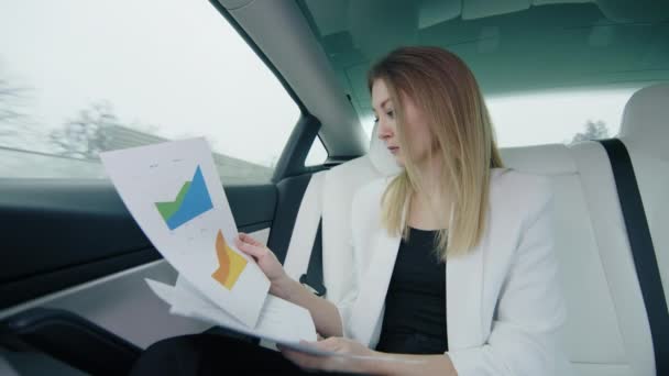 Piękna Dziewczyna Tylnym Siedzeniu Samochodu Pracuje Dokumentami Wykresami Wyglądającymi Skupioną — Wideo stockowe