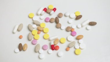 Beyaz bir masada, birçok renkli tabletler dağıtılmıştır. Tek hamlede tüm tabletleri masadan kaldıran bir el, sağlıklı bir yaşamın birincil yolunun tıp olmadığını sembolize eder..