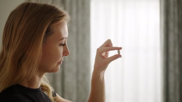 Güzel Bir Kız Bir Hapı Inceler Onu Elinde Çevirir Alıp — Stok video