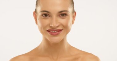 Bir kızın başını kaldırıp kameraya baktığı ve mükemmel bir gülümsemeyle ideal beyaz dişlerini sergilediği yakın çekim. O, dilini nazikçe dişlerinin üzerinde gezdirir. 4K video
