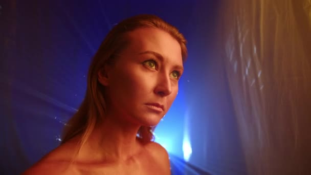 Modell Med Gyllene Hud Poserar Framför Kameran Nära Transparenta Ljusridåer — Stockvideo
