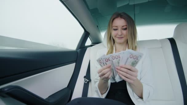 Beyaz Ceketli Işıldayan Genç Bir Kadın Bir Arabanın Arka Koltuğunda — Stok video
