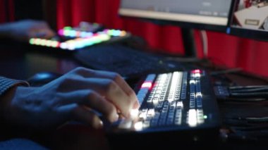 KYIV, UKRAINE, 2 Aralık 2023. Video kontrol panelinin farklı düğmelerini değiştiren bir elin yakın çekimi. Stüdyo bloglar ve yayınlar için tasarlandı..