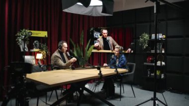 KYIV, UKRAINE, 2 Aralık 2023. Bir adam ve bir kadın video stüdyosundaki bir masada tartışıyorlar. Çevrelerinde ekipmanlar, kameralar, ışıklar ve diğer teknik cihazlar bulunuyor..