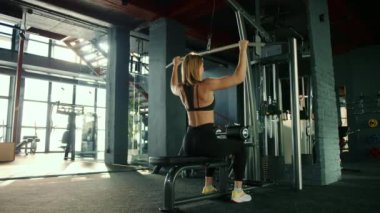 Spor salonunda dikey blok hareketi yapan genç bir kız. O çok hedefe odaklı ve ısrarcı. Yüksek kalite 4k görüntü