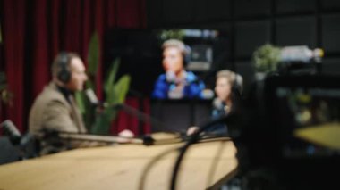 KYIV, UKRAINE, 2 Aralık 2023. Stüdyodan panoramik bir görüntü bir masada iki kişiyi çeken bir kamera görüntüsü. Video stüdyosunda, genç insanlar hoş bir sohbete girişiyor.