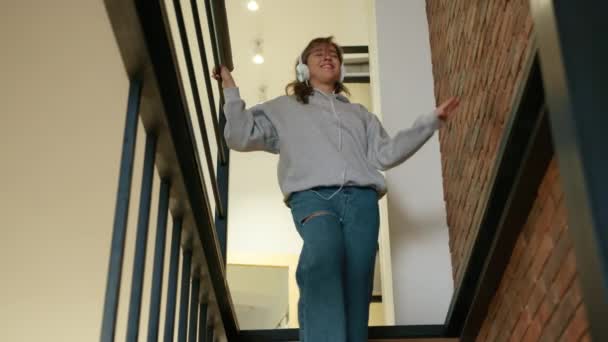 Beautiful Girl Headphones Descends Stairs Her Modern House She Goes — Stock Video