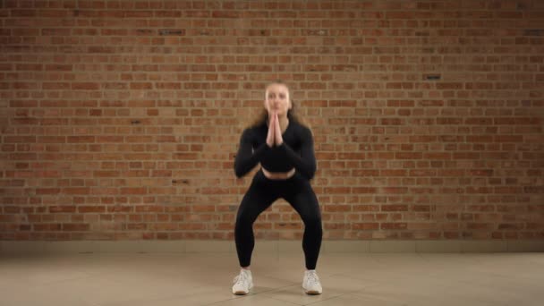 Девушка Кирпичной Стены Выполняет Упражнение Приседание Качели Ноги Сторону Тренер — стоковое видео