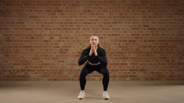 Een Vrouwelijke Trainer Demonstreert Knieoefeningen Toont Beweging Een Stijlvolle Fitnessruimte — Stockvideo