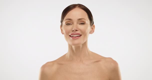 裸の肩を持つブルネットの輝く笑顔 女性は彼女の完璧な肌を示し 細心の注意を払って維持しています アンチエイジングスキンケア製品の広告 レッド Raw — ストック動画