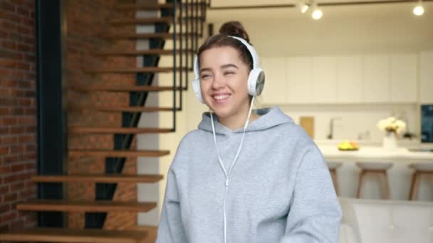 Sama Dziewczyna Słucha Muzyki Słuchawkami Stylowym Mieszkaniu Uśmiecha Się Tańczy — Wideo stockowe