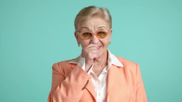 一位漂亮 整洁的女士 年龄超过60岁 面带微笑 身穿白衬衫 苍白的桃色夹克 脸上流露出沉默的痕迹 并小心地指尖食指 高质量的4K镜头 — 图库视频影像