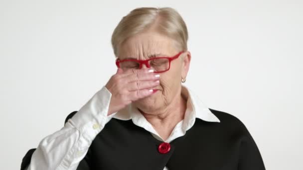 有趣的老年妇女 金发碧眼 皱纹很深 手拿着红边眼镜捂住嘴 朝前打喷嚏 涂着鲜红的口红 高质量的4K镜头 — 图库视频影像