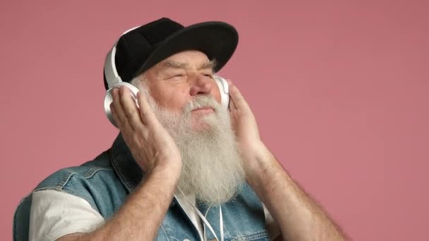 Pria Tua Dengan Janggut Putih Panjang Mengenakan Headphone Dan Topi — Stok Video