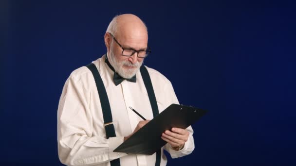 Мужчина Белой Рубашке Бабочкой Подтяжками Пишет Своих Бумагах Поднимает Голову — стоковое видео