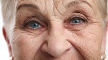 60-70 yaş arası mutlu, hoş görünümlü, buruşuk suratlı, düzgün kaşlı, gözlerinde oklar, doğal yaşlanma, bilgelik ve güzellik, iyi kalpli büyükanne. Yüksek kalite 4k görüntü