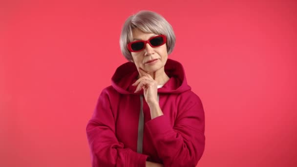 Fashion Forward Senior Vrouw Overweegt Een Rode Hoodie Trendy Zonnebril — Stockvideo