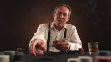 Poker oyununa dalmış, ağzı yanan bir puro ve elinde viski bardağıyla güvenle bahis oynayan, odaklanmış bir ifadeye sahip yaşlı bir adam. Kamera 8K HAM.
