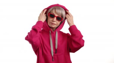 Zarafet ve rahatlık göstergesi olarak, olgun bir kadın nazikçe başlığını çıkarır, yavaş çekim görüntüsü, onun rahat ve memnun halinin özünü yakalar. Kamera 8K HAM. 