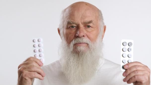 Skeptical Senior Man White Beard Shakes His Head Holding Two — Stock Video