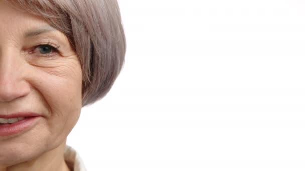 65歳の女性の放射性で楽しい顔の半分がフレームを埋め シニアスキンケア広告を統合するための理想的な空白スペースを提供します カメラ Raw — ストック動画