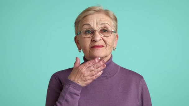 Нежная Милая Пожилая Женщина Глубокими Морщинами Фиолетовой Водолазке Стоящая Синем — стоковое видео