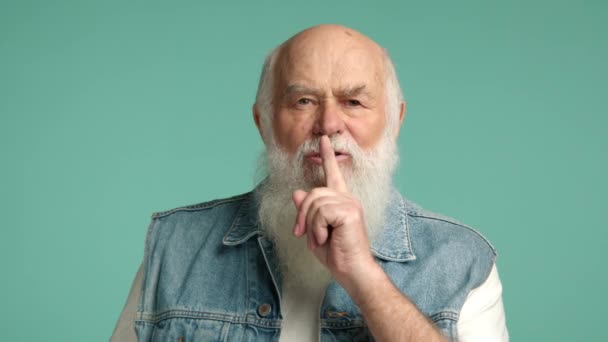 Äldre Gentleman Jeansväst Sätter Ett Finger Läpparna Och Signalerar Tystnad — Stockvideo