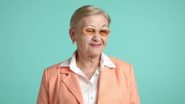 快乐的金发女郎 60岁至70岁 皱纹很深 身穿白衬衫和橙色夹克 在镜头前开怀大笑 飞的奶奶 高质量的4K镜头 — 图库视频影像