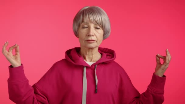 Eine Ruhige Seniorin Einem Satten Kastanienbraunen Kapuzenpulli Meditiert Mit Geschlossenen — Stockvideo