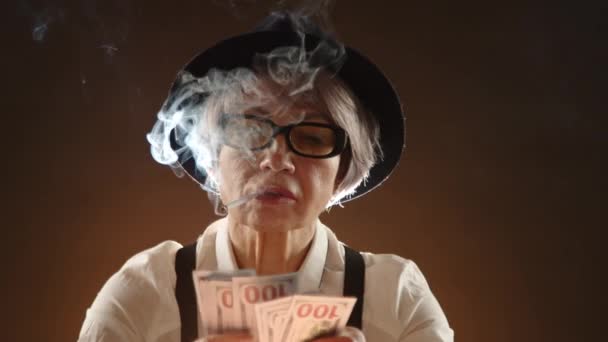 Stylish Senior Woman Smokes Cigarette While Confidently Holding Fan One — Stock Video
