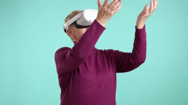 穿着勃艮第高领毛衣的身材瘦小的老妇人测试虚拟现实耳机 在太空中移动双手 玩游戏 与虚拟现实互动 高质量的4K镜头 — 图库视频影像