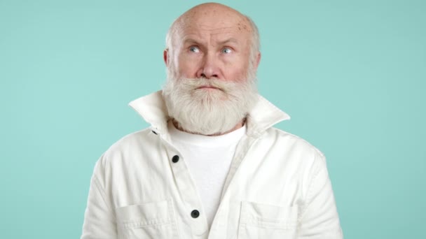 Скромный Пожилой Человек Молодой Белой Куртке Закрывает Лицо Рукой Бирюзовом — стоковое видео
