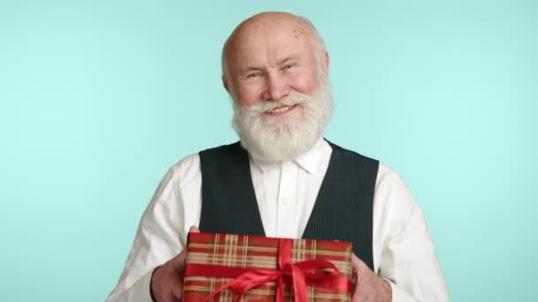 Cheerful Senior Man Presenting Tartan Wrapped Gift Box Bright Red — Stock Video