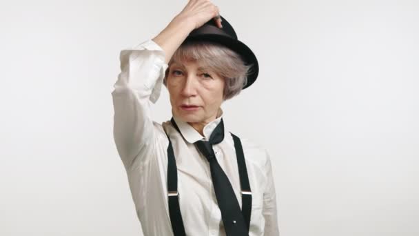 高傲的老妇人 手放在下巴上 头戴帽子 头戴吊袜带 背景是白色的 高质量的4K镜头 — 图库视频影像