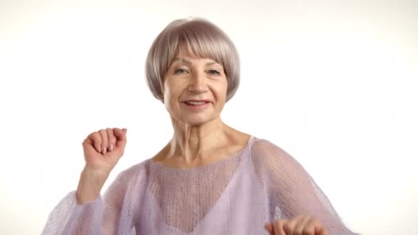 精力充沛的老太太快乐地跳舞 穿着舒适的紫色毛衣 表达着自由和快乐 象征着活力和积极的生活方式 8K照相机 — 图库视频影像