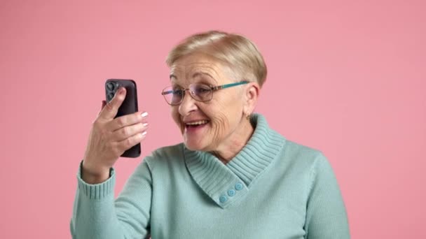 年龄在60 70岁之间的优雅女士 修指甲 在手机上视频聊天 挥手致意 友善地说话 高质量的4K镜头 — 图库视频影像