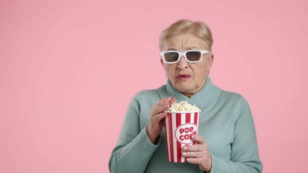 Verschrikte Seniorenvrouw Die Popcorn Eet Uit Papieren Beker Roze Achtergrond — Stockvideo