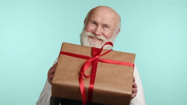 Delightful Senior Man Beams Lifts Beautifully Wrapped Gift Red Ribbon — Stock Video