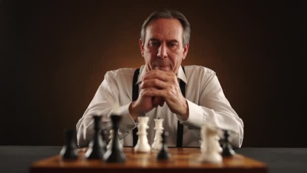 Seasoned Strategist Formal Attire Discerning Gaze Sits Chessboard Contemplating Potential — Stock Video