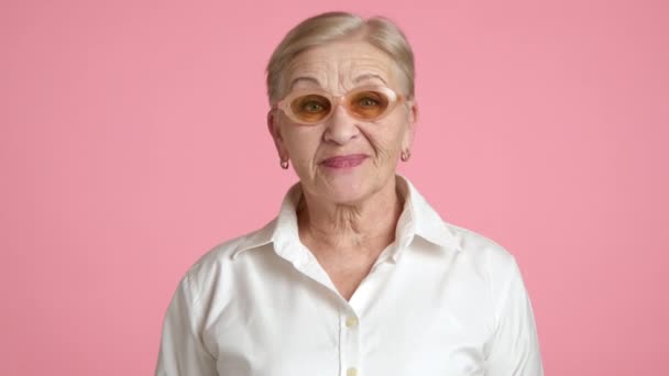 80歳の女性ブロンドは メイクアップのノッディングヘッドで 笑顔で白いシャツ 合意にうなずく素敵な老婆の中型ショット 何かを確認する 高品質の4K映像 — ストック動画