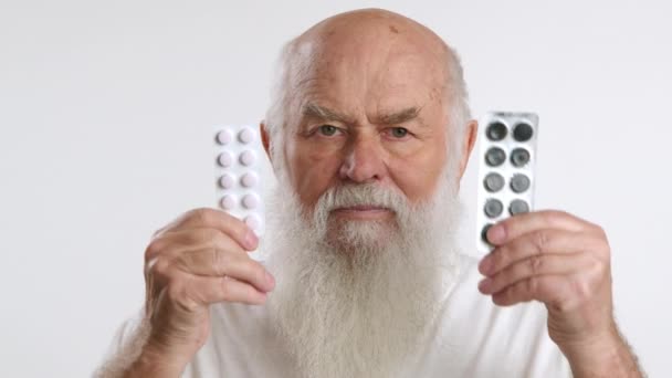 Старий Чоловік Красивою Легкою Бородою Піднімає Два Блістерних Пачки Таблеток — стокове відео