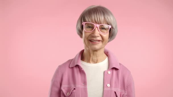 Egy Vidám Idős Ragyogó Mosollyal Rózsaszín Kabátban Megfelelő Szemüvegben Egyetértésben — Stock videók
