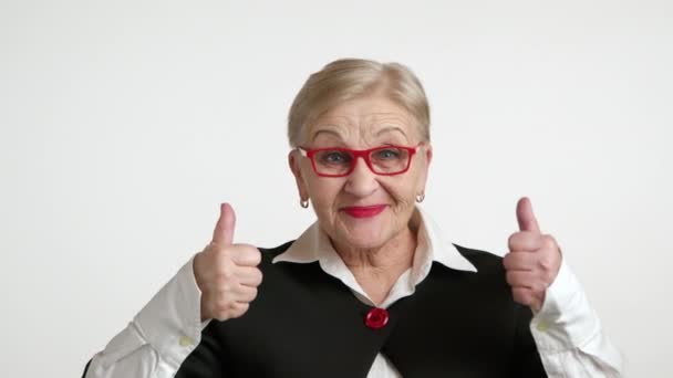 漂亮的金发老太太享受着成功 穿着红边眼镜 身穿白衬衫 黑色夹克的优雅的老年女性 高质量的4K镜头 — 图库视频影像