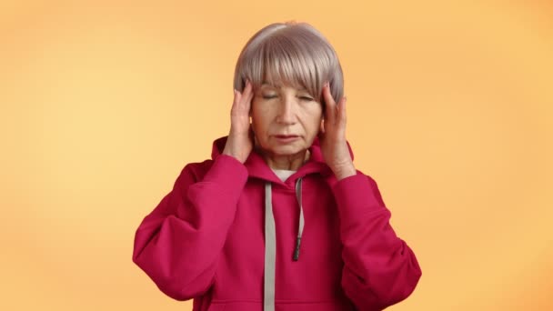 Elderly Woman Pink Hoodie Appears Distressed Pressing Her Temples Indicating — Stock Video