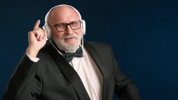 Hombre Elegantemente Vestido Con Aire Sofisticado Con Auriculares Tocando Ritmo — Vídeos de Stock