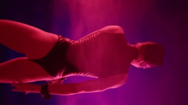 Bu dikey video, parlak, siyah kedi temalı BDSM kostümlü, kelepçeli, dumanlı, mor bir zemin üzerine kurulmuş baştan çıkarıcı bir gizem barındırıyor. Yüksek kalite 4k görüntü