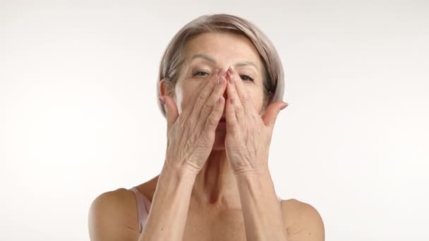 Graceful Senior Lady Med Ett Subtilt Leende Applicera Fuktighetskräm Ansiktet — Stockvideo